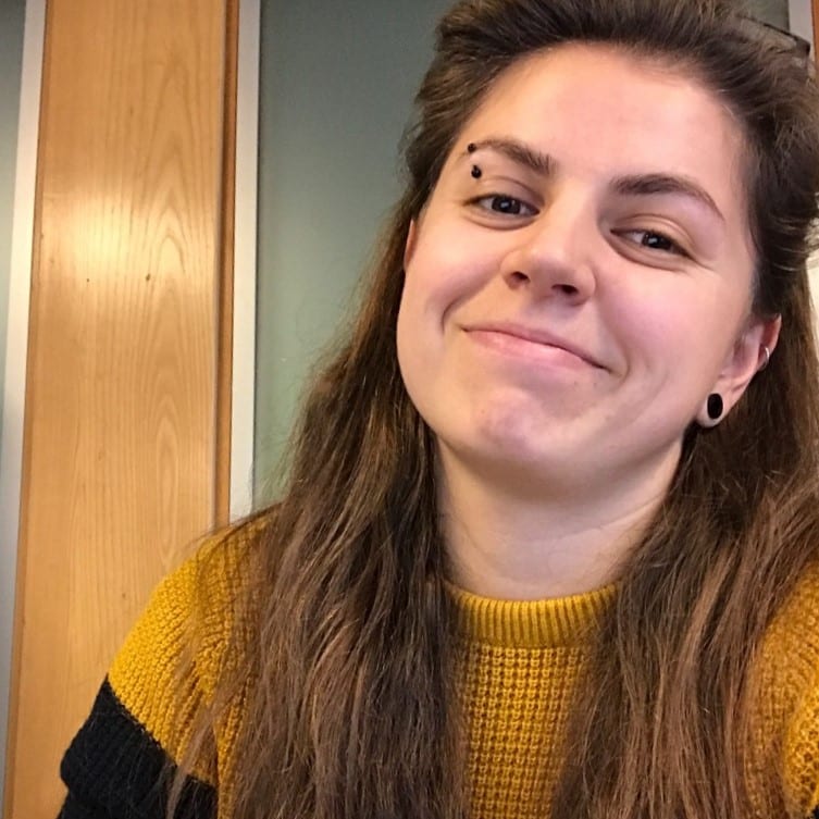 A selfie taken by a female with brown hair smiling